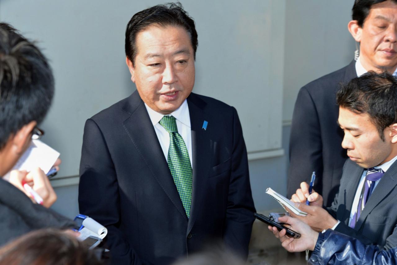 'Japanese Prime Minister and leader of the ruling Democratic Party of Japan Yoshihiko Noda (C) speaks to reporters after casting his vote in the general election at a polling station in Funabashi, sub