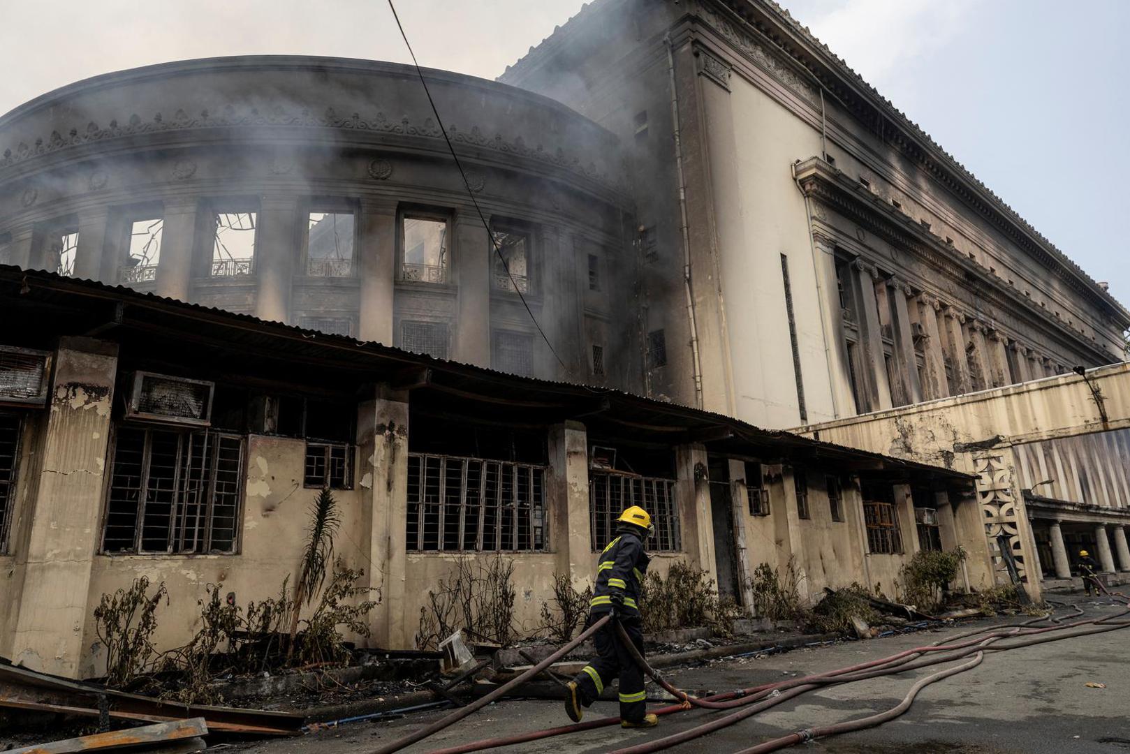 A firefighter pulls a hose to douse the burning Manila Central Post Office building after a massive fire, in Manila, Philippines, May 22, 2023. REUTERS/Eloisa Lopez Photo: ELOISA LOPEZ/REUTERS