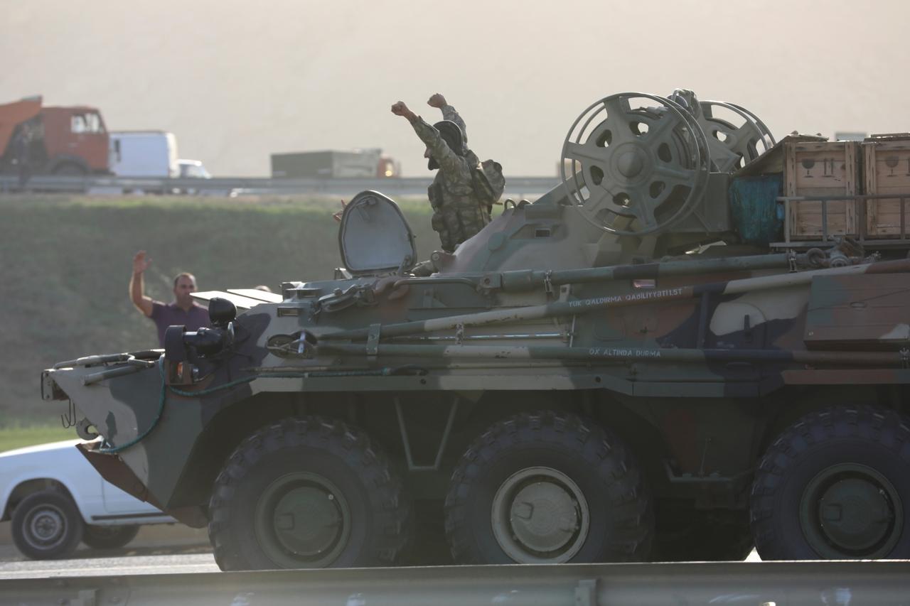 An Azerbaijani service member drives an armoured carrier in Baku