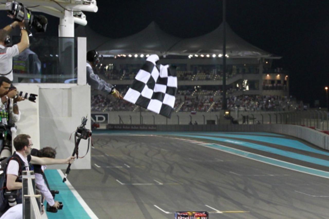 'Red Bull Formula One driver Sebastian Vettel of Germany crosses the finish line to win the Abu Dhabi F1 Grand Prix at Yas Marina circuit in Abu Dhabi November 14, 2010. REUTERS/Caren Firouz   (UNITED