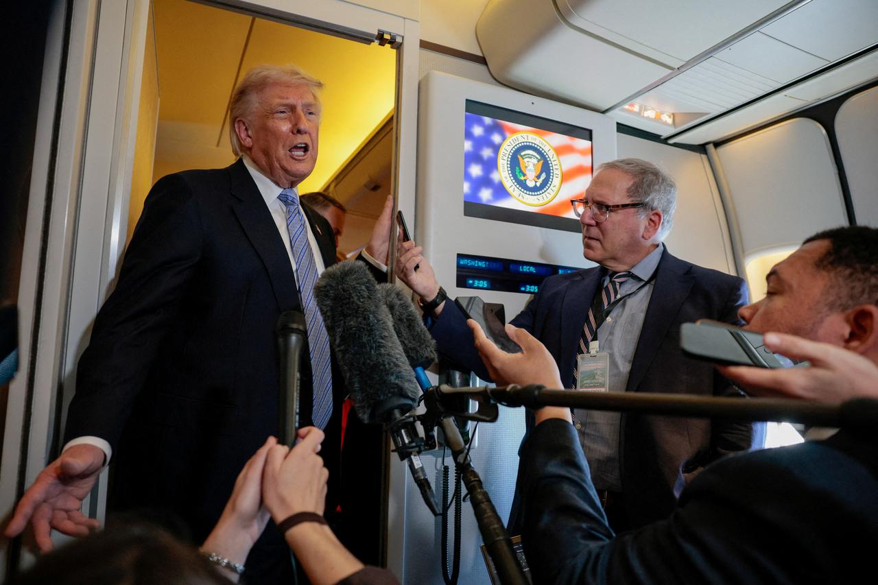FILE PHOTO: U.S. President Donald Trump speaks to members of the media on board Air Force One, following his visit to China