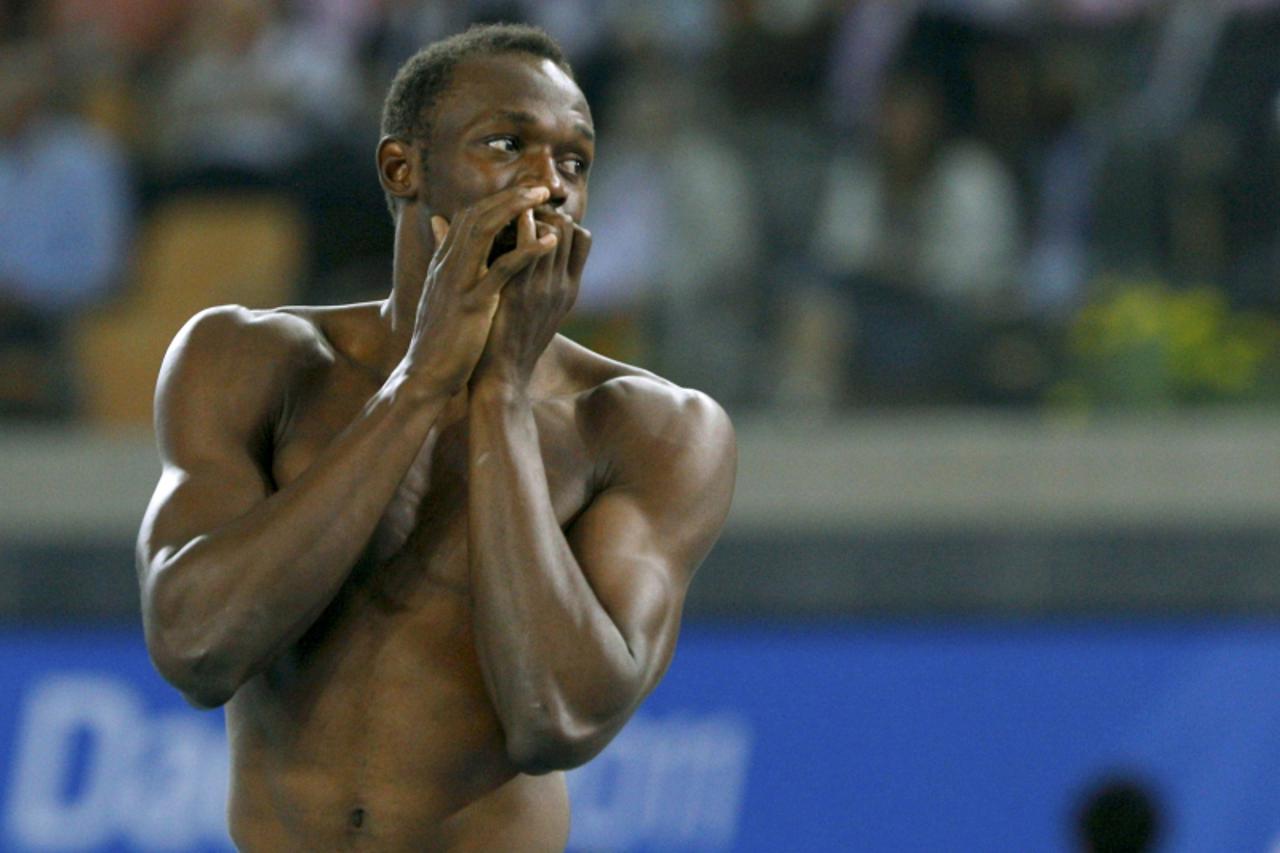 'Usain Bolt of Jamaica walks without his shirt after being disqualified for a false start during the men\'s 100 metres final at the IAAF World Championships in Daegu August 28, 2011.     REUTERS/Phil 