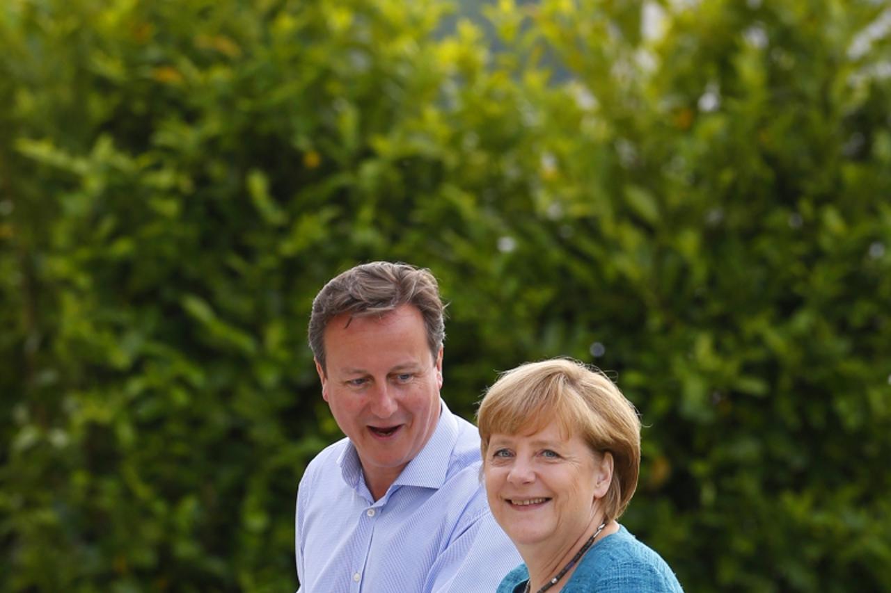 'Britain\'s Prime Minister David Cameron (L) welcomes Germany\'s Chancellor Angela Merkel to the Lough Erne golf resort where the G8 summit is taking place in Enniskillen, Northern Ireland June 17, 20