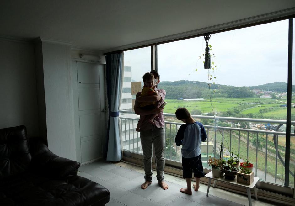 Shahpoor Ahmad Azimi shares a moment with his children at his house in Yongin
