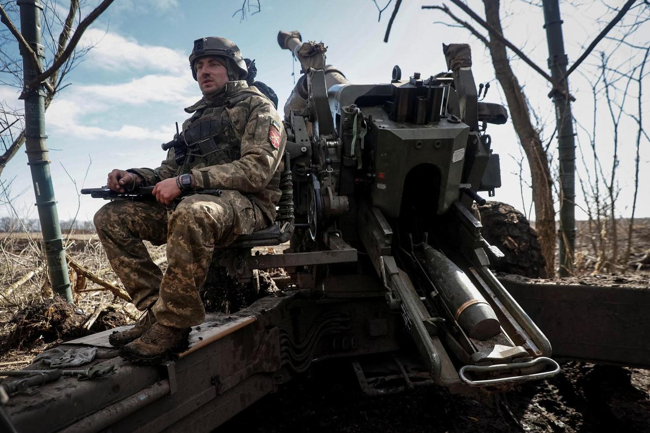A Ukrainian service member is seen on a towed howitzer FH-70 at a front line in Zaporizhzhia Region