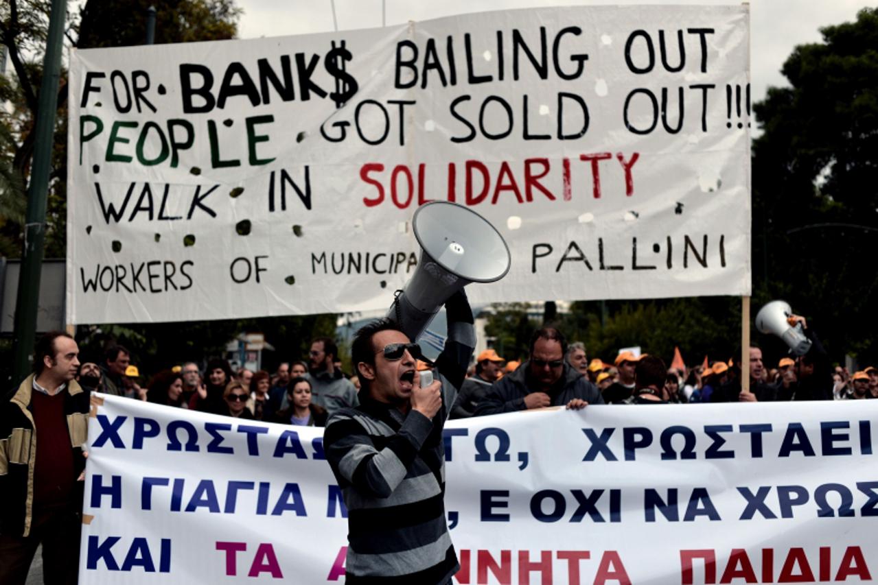 'A municipality worker shouts a slogan during a demonstation outside the Interior Ministry against the new austerity measures in Athens on November 23, 2012.  The EU and the International Monetary Fun