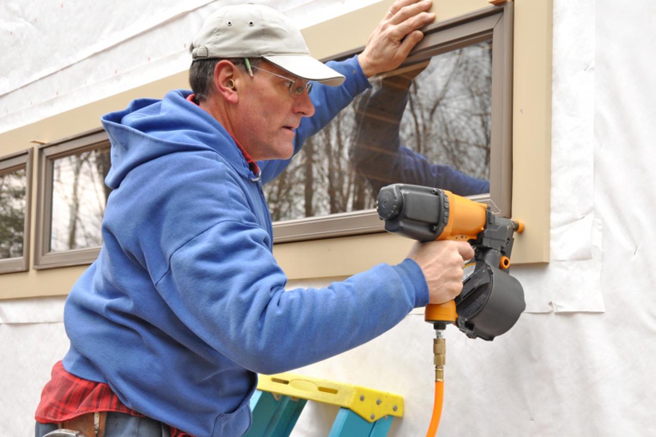 'Carpenter using nail gun'
