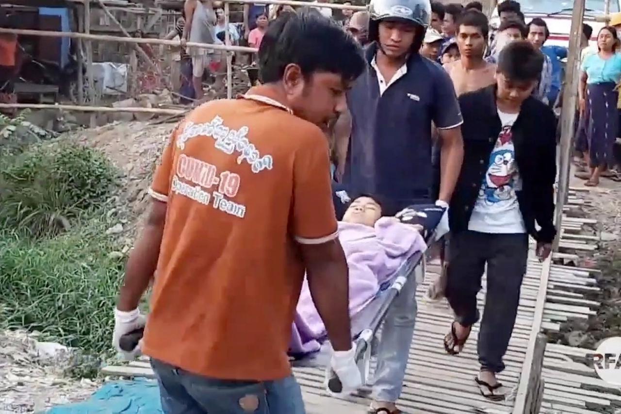 People look on during the funeral of Tun Tun Aung, a 15-year-old, who was killed in his hut when security forces opened fire, in Mandalay, Myanmar in this still frame obtained from local media video