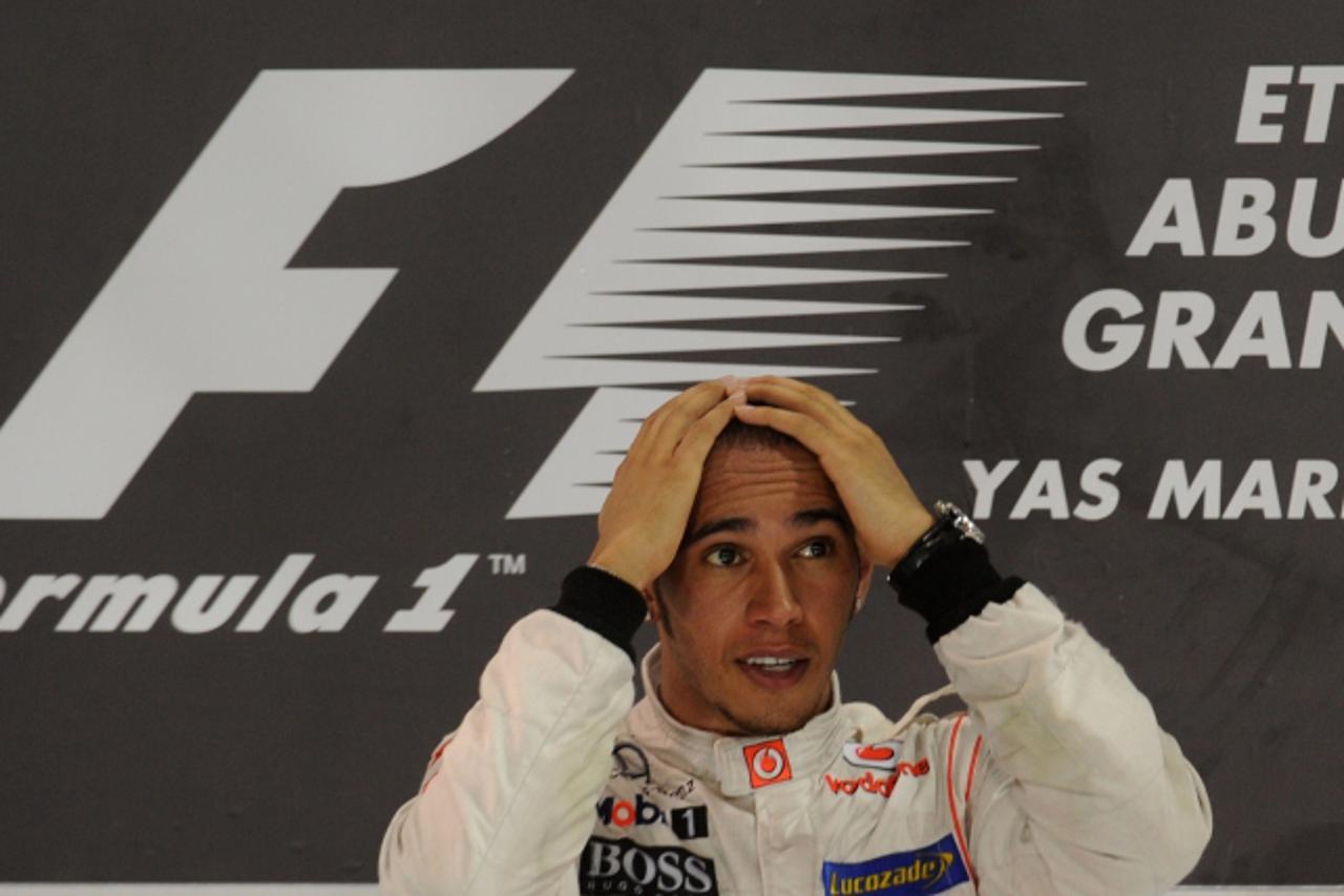'McLaren Mercedes\' British driver Lewis Hamilton celebrates winning on the podium  at the Yas Marina circuit on November 13, 2011 in Abu Dhabi after the Abu Dhabi Formula One Grand Prix. AFP PHOTO / 
