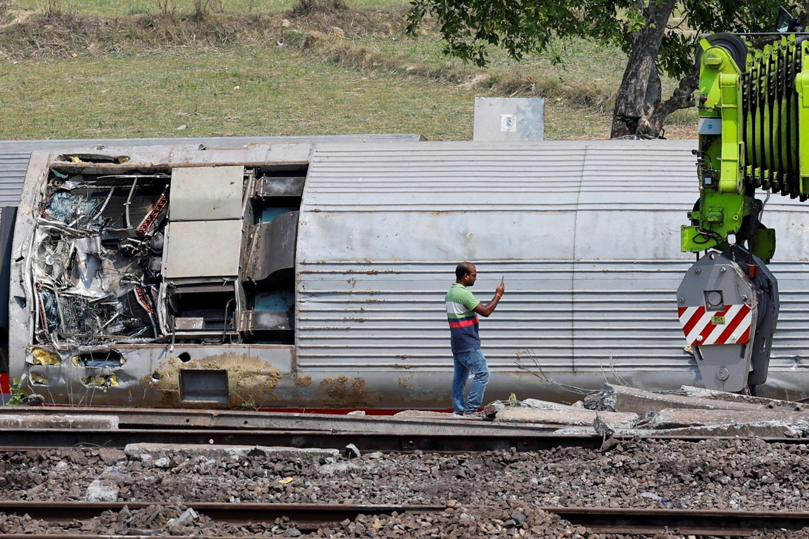 A man takes pictures of a damaged coach at the site of a train collision following the accident in Balasore district in the eastern state of Odisha, India, June 4, 2023. REUTERS/Adnan Abidi Photo: ADNAN ABIDI/REUTERS