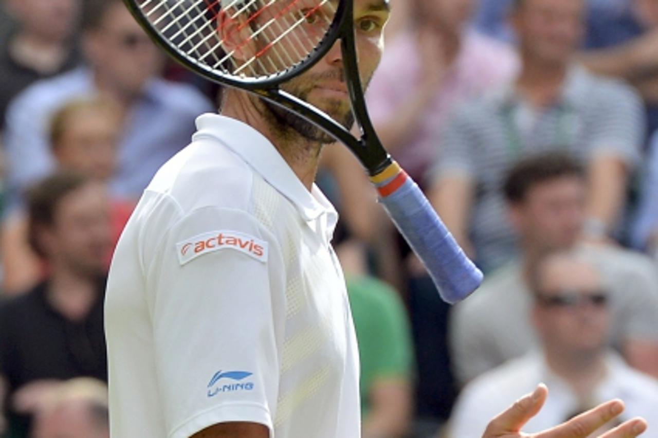 'Ivo Karlovic of Croatia throws his racquet during his men\'s singles tennis match against Andy Murray of Britain at the Wimbledon tennis championships in London June 28, 2012.       REUTERS/Toby Melv