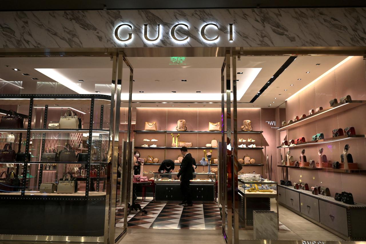FILE PHOTO: Staff members wearing face masks are seen inside a store of an Italian luxury brand Gucci at a shopping mall, as the country is hit by an outbreak of the novel coronavirus, in Beijing