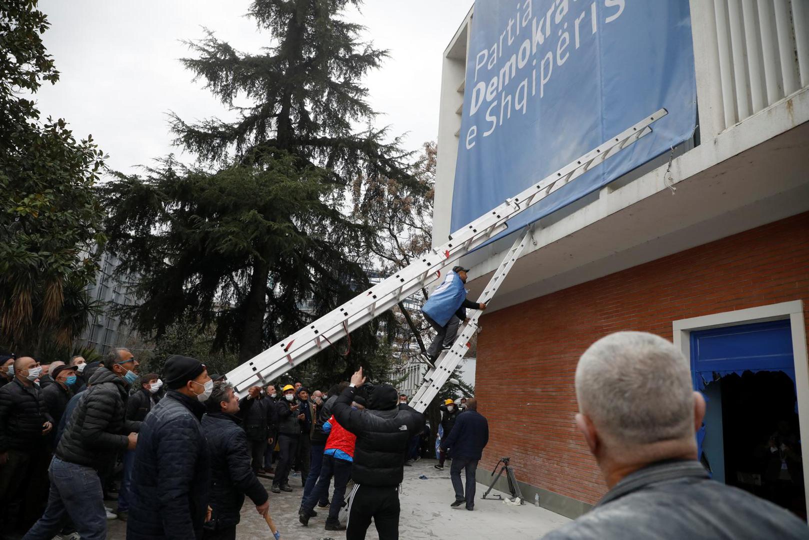 Protesters use ladders as they demonstrate outside the headquarters of the Democratic Party in Tirana, Albania, January 8, 2022. REUTERS/Florion Goga Photo: Florion Goga/REUTERS
