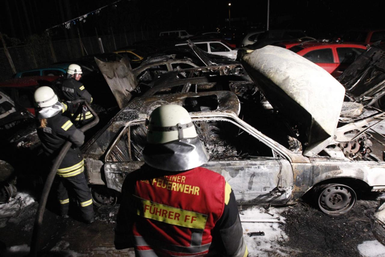 \'Firefighters extinguish a fire in the yard of a car retailer in the Schmoeckwitz district of Berlin August 19, 2011.  German politicians urged tough action on Thursday against a surge in arson attac