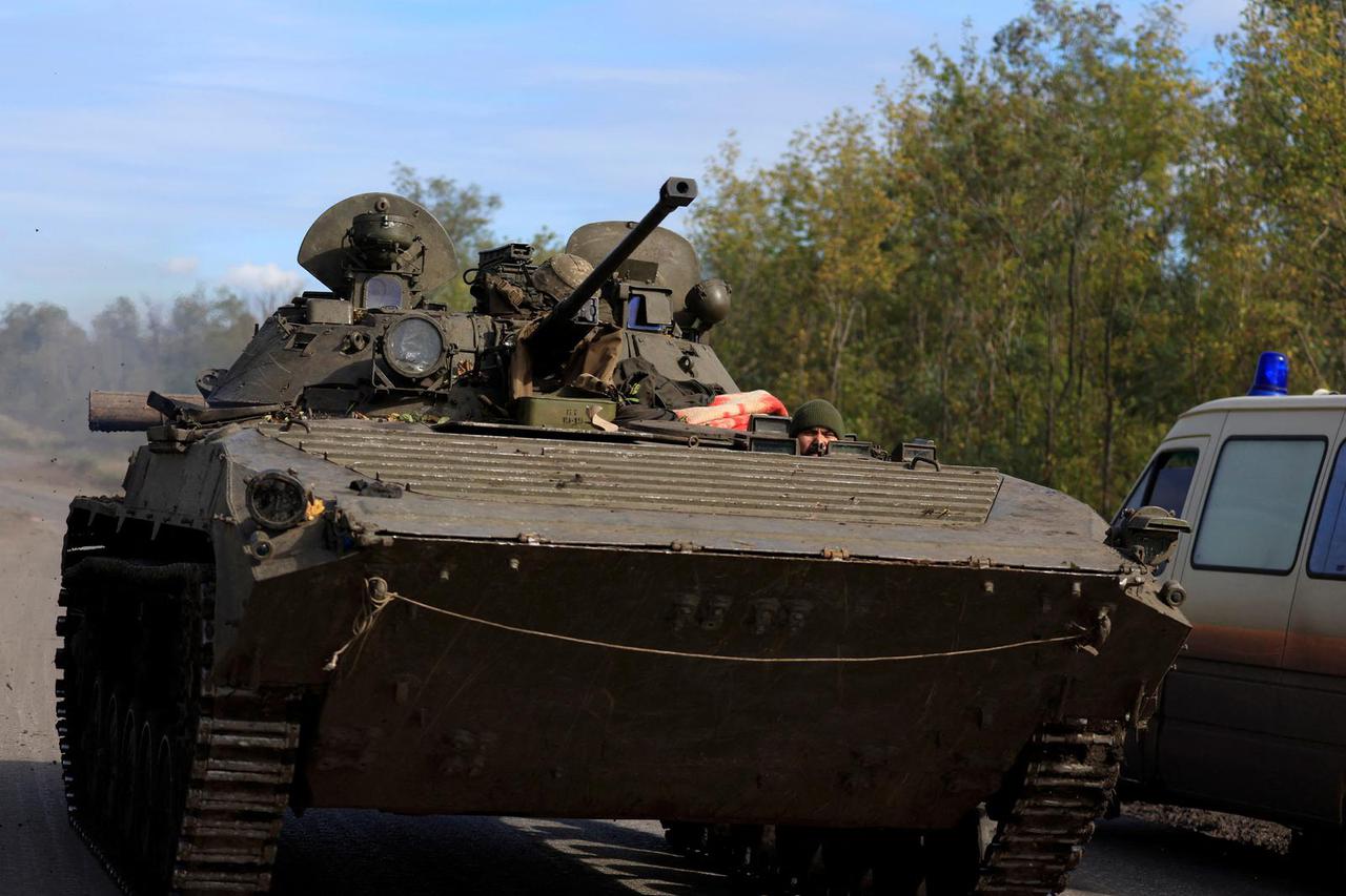 Ukrainian rides an armoured vehicle outside Bakhmut