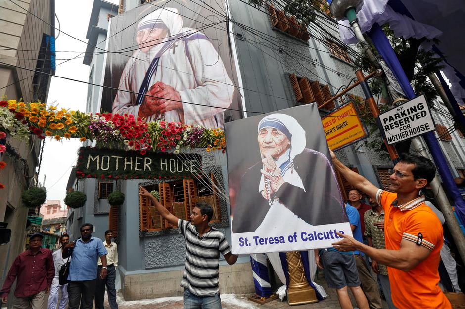A man holds a poster of Mother Teresa outside the  Missionaries of Charity building in Kolkata as she was canonised during a ceremony held in the Vatican, India September 4, 2016. REUTERS/Rupak De Chowdhuri     TPX IMAGES OF THE DAY