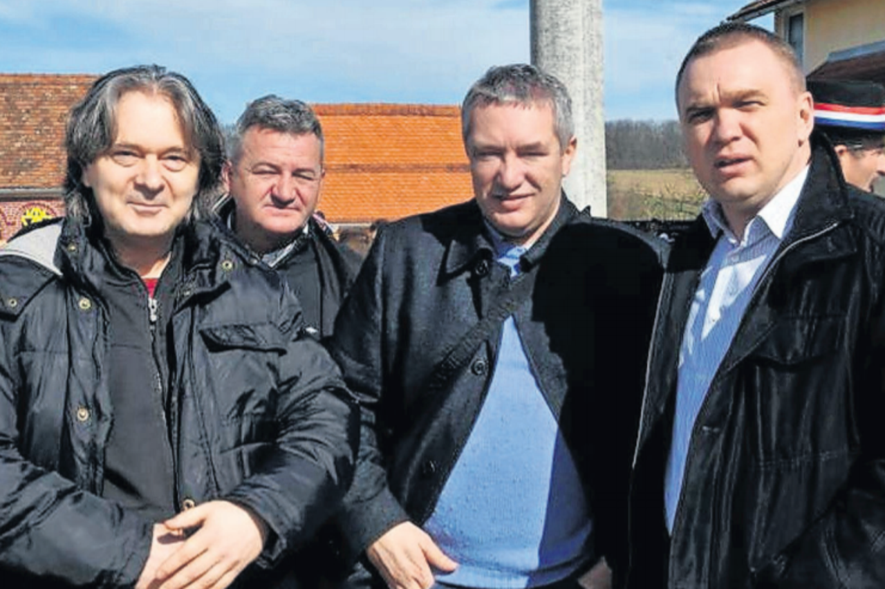 Dragan Kovačević u obiteljskom dvorištu u Brodskom Drenovcu 2014. s tamburašem Stankom Šarićem (lijevo) i dožupanom slavonsko-požeškim Vedranom Neferovićem (desno)