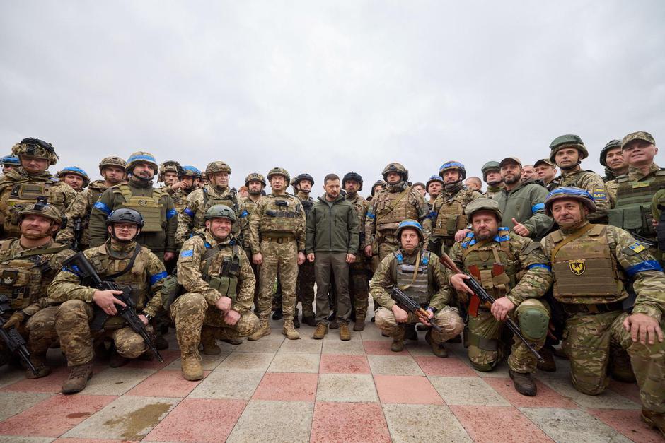 Ukraine's President Zelenskiy poses for a group picture with Ukrainian service members in the recently liberated town of Izium