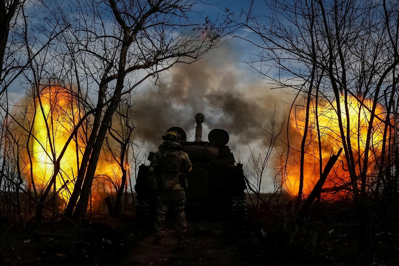 Ukrainian servicemen fire a self-propelled howitzer toward Russian positions on a frontline in Donetsk region