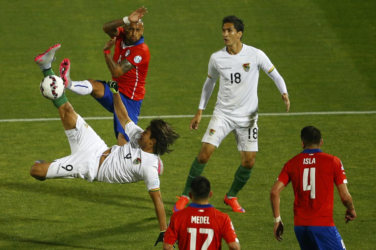 Bolivia's Marcelo Martins kicks the ball next to Chile's Arturo Vidal as Bolivia's Ricardo Pedriel and Chile's Gary Medel and Mauricio Isla look on during their first round Copa America 2015 soccer match at the National Stadium in Santiago, Chile, June 19