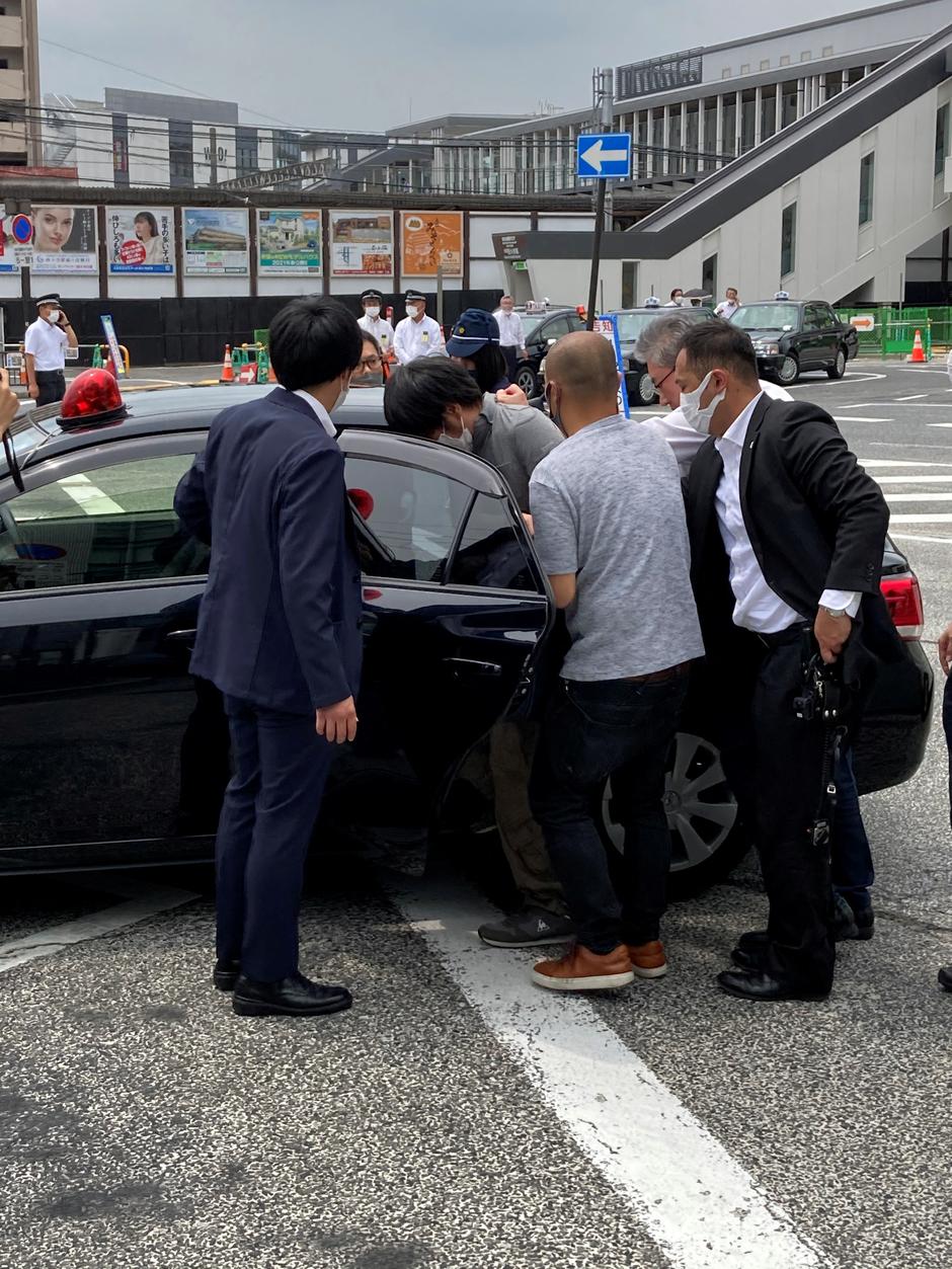 A suspect who is believed to have shot former Japanese Prime Minister Shinzo Abe is ushered to a car in Nara