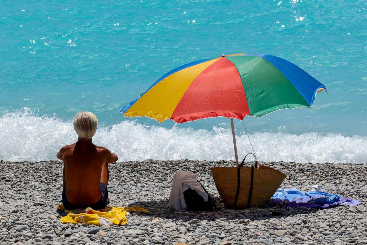 A man sits on the beach in Nice