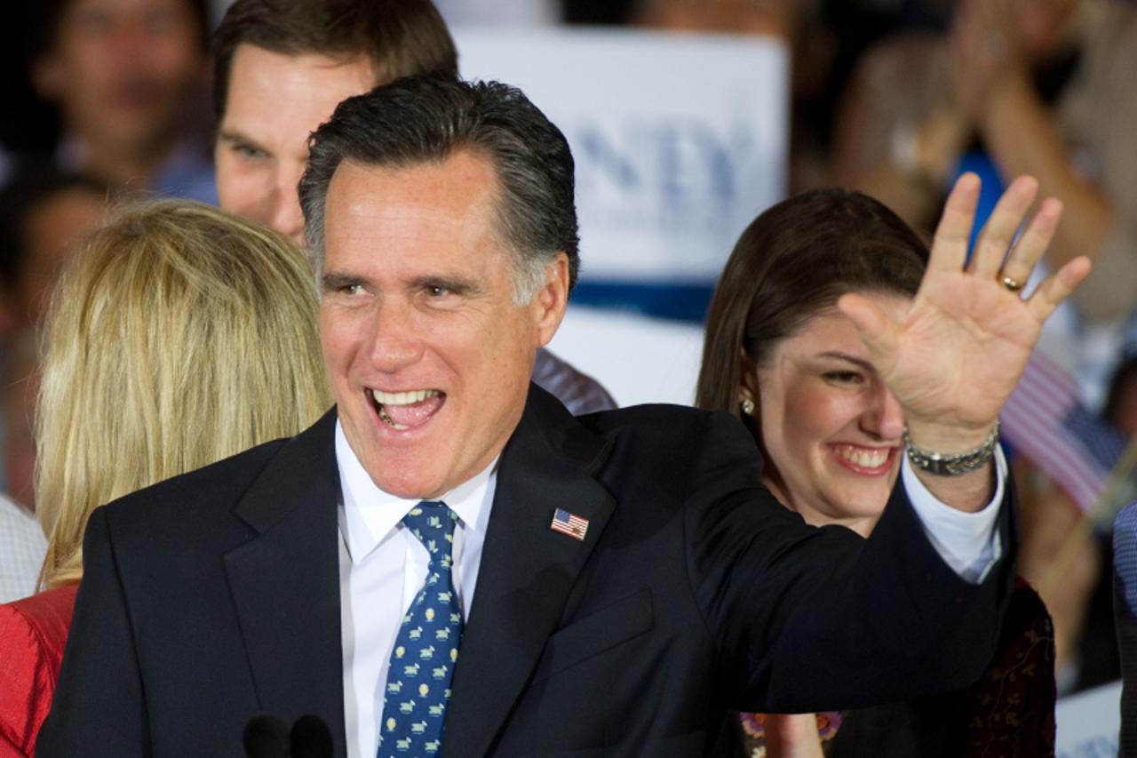 'Florida Republican primary winner Mitt Romney waves to the crowd gathered at election night headquarters inside the Tampa Convention Center January 31, 2012, in Tampa, Florida.    AFP Photo/Paul J. R