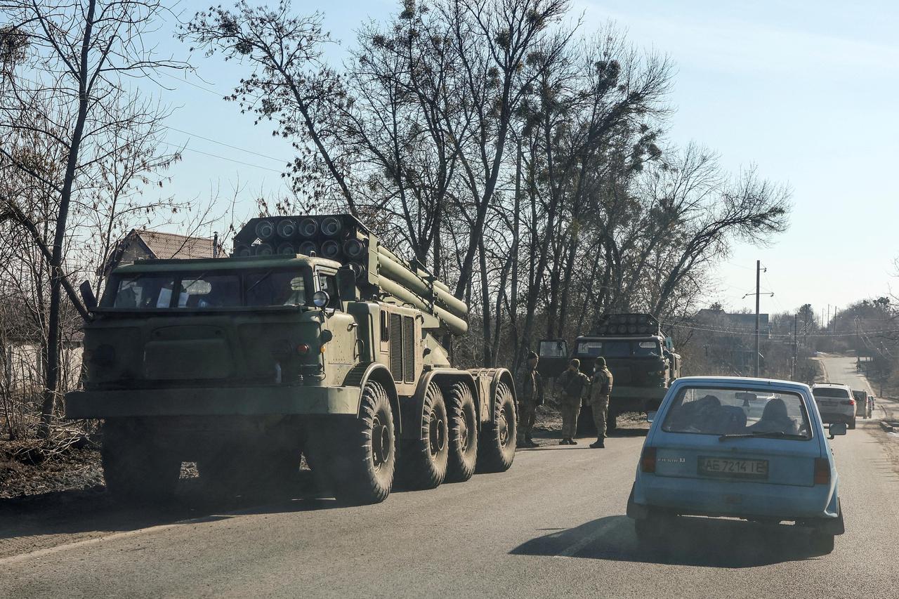 Ukrainian army soldiers stand next to multiple launch missile systems in Kharkiv region