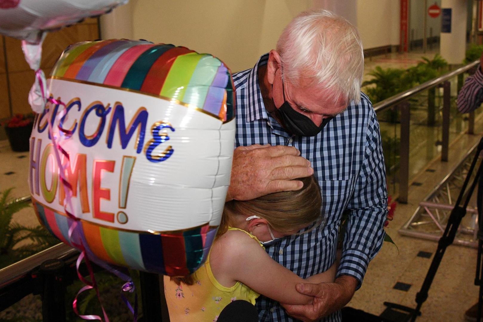 Charlotte Roempke, 8, welcomes her grandfather Bernie Edmonds as he arrives at Sydney International Airport after Australia reopened its international borders to travelers vaccinated against the coronavirus disease (COVID-19), in Sydney, Australia February 21, 2022. AAP Image/Dean Lewins via REUTERS ATTENTION EDITORS - THIS IMAGE WAS PROVIDED BY A THIRD PARTY. NO RESALES. NO ARCHIVE. AUSTRALIA OUT. NEW ZEALAND OUT. Photo: Stringer/REUTERS
