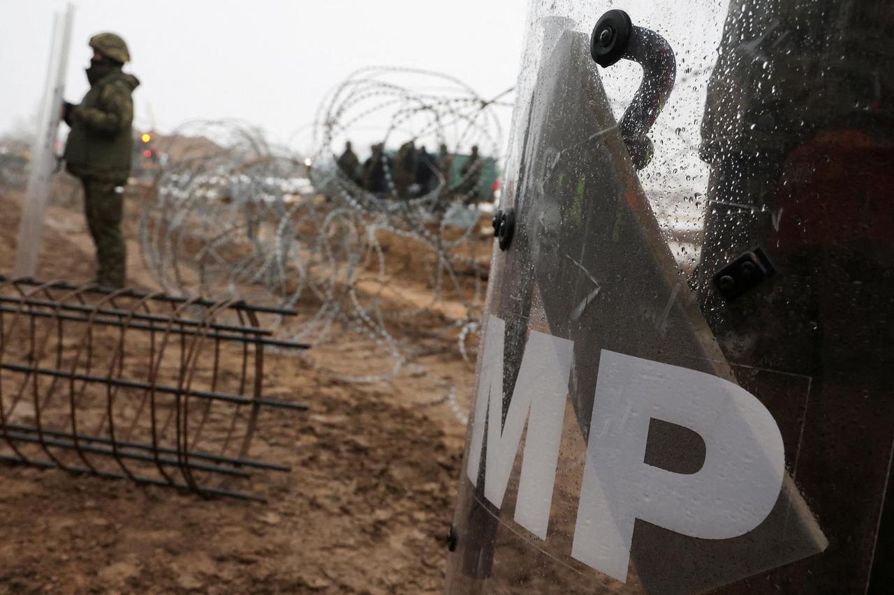 FILE PHOTO: Workers work at construction site of barrier at border between Poland and Belarus