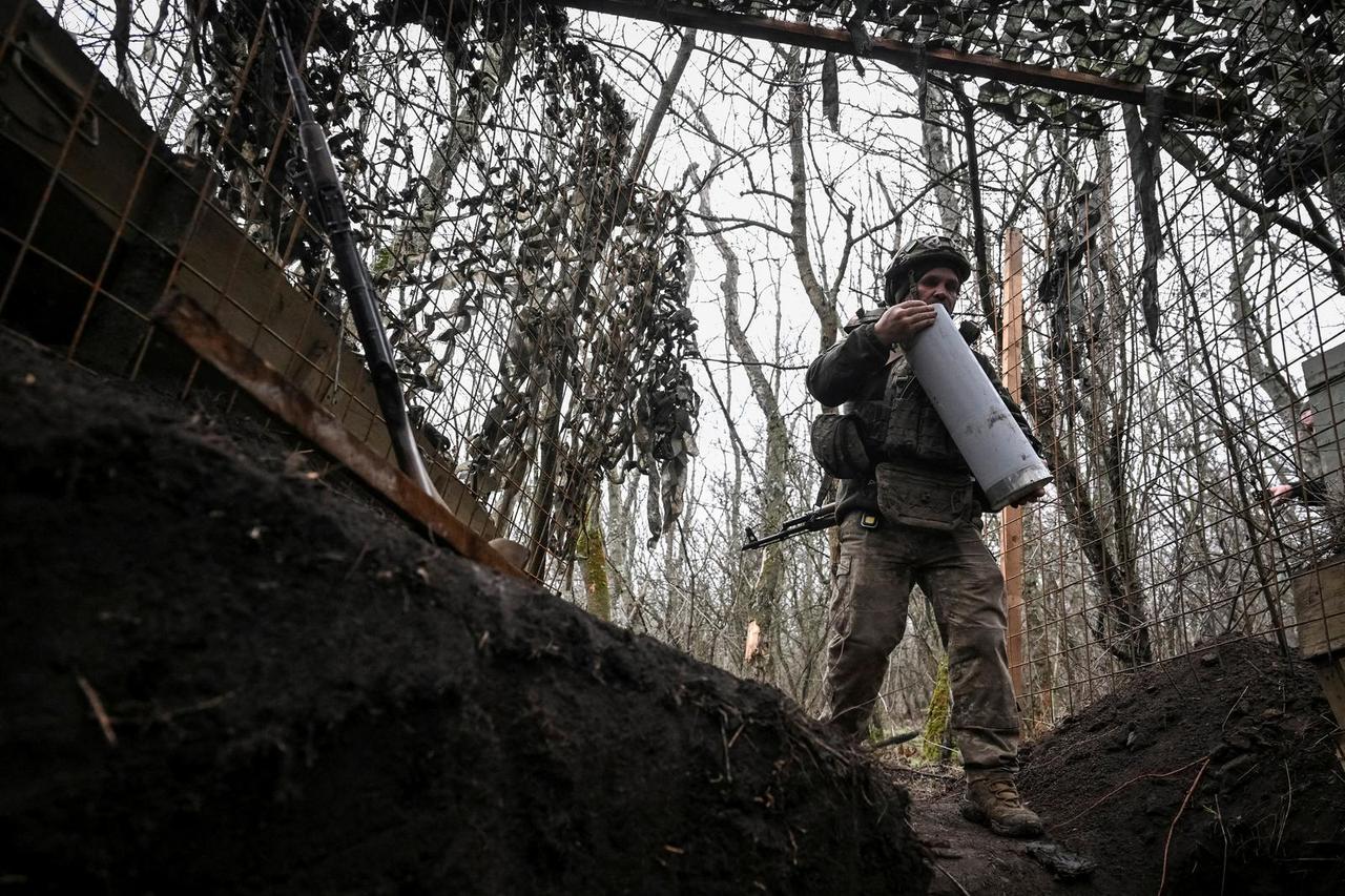 FILE PHOTO: Ukrainian servicemen fire a howitzer towards Russian troops near the frontline town of Pokrovsk