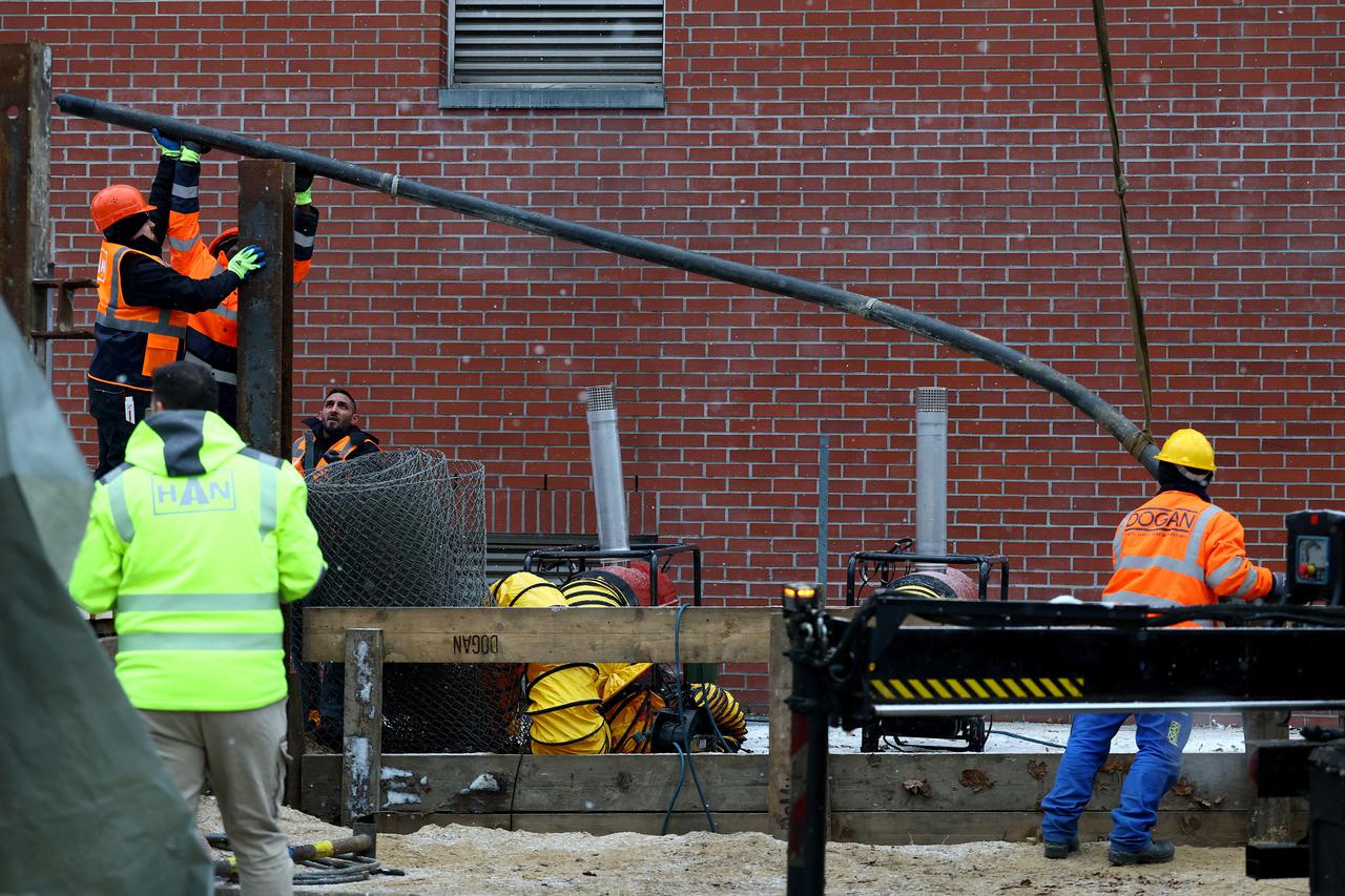 Workers lay a 110 kilovolt high-voltage cable on a construction site to restore electricity during a blackout in Berlin