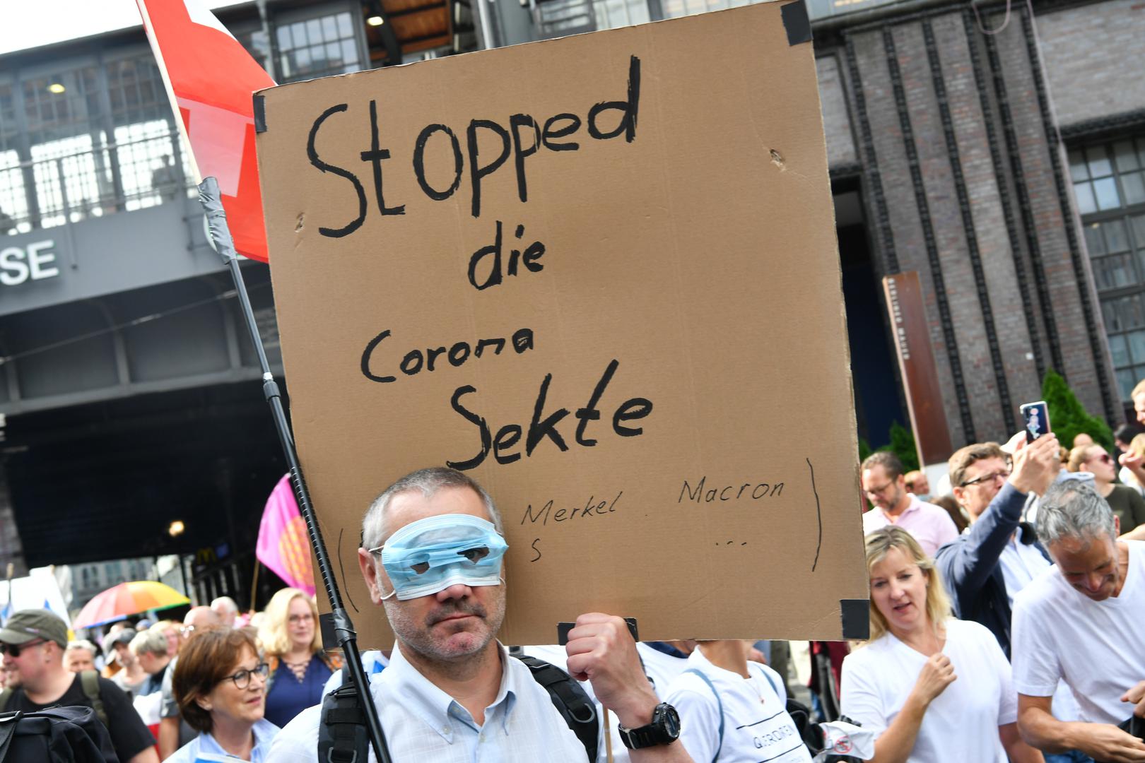 29 August 2020, Berlin: A participant with a mouth guard over his eyes and the sign "Stopped the Corona Sect" is standing in Friedrichstraße during a demonstration against the Corona measures. Photo: Paul Zinken/dpa /DPA/PIXSELL