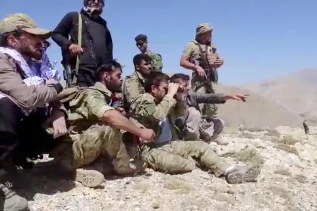 Members of National Resistance Front observe from a hill in Panjshir Valley