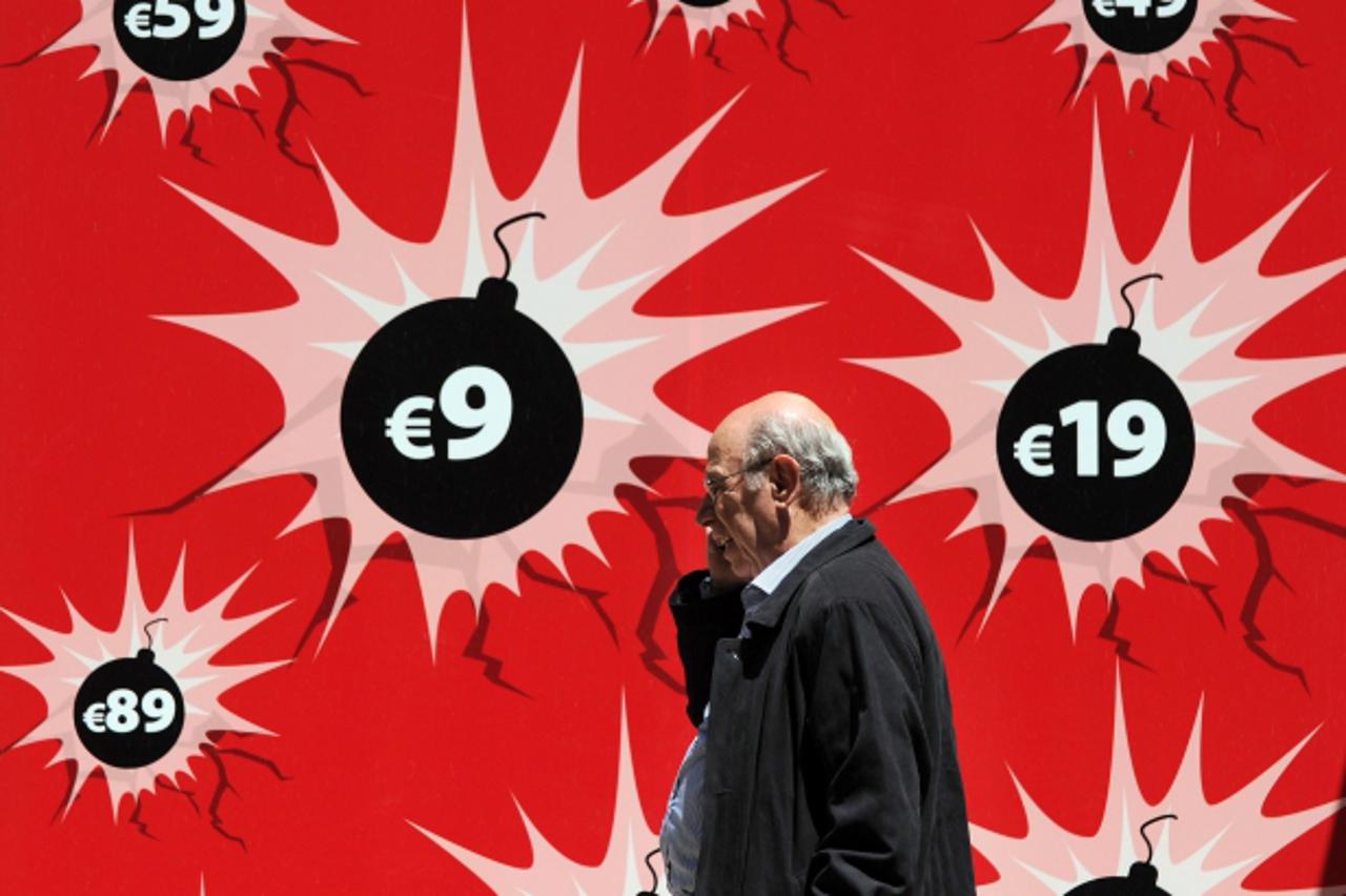 'TOPSHOTS A man passes by a shop window in downtown Athens on May 2, 2010. Greece plans new budget cuts of 30 billion euros over three years with the aim of slashing the public deficit to less than th