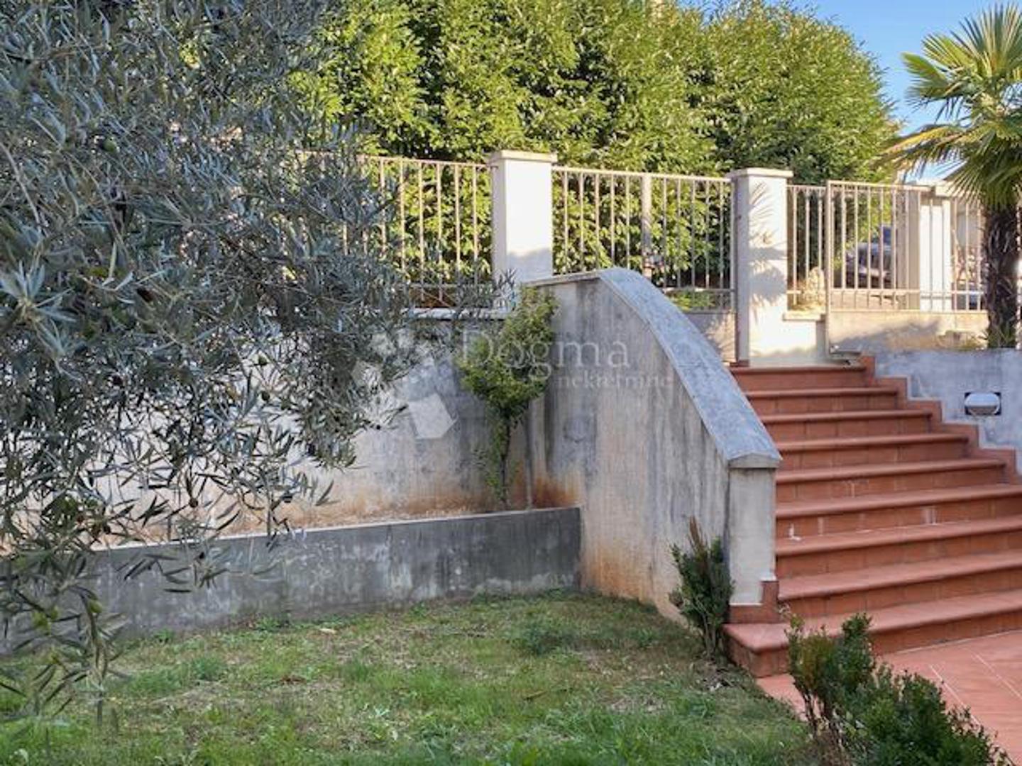 Prizemlje nudi vrlo prostrani dnevni boravak, blagovaonicu, kuhinju, još jednu smočnicu, radnu sobu te izlaz na kombiniranu otkrivenu i natkrivenu terasu, kao i lođu. U sklopu prizemlja nalazi se i garaža u koju mogu stati dva do tri vozila, ovisno o njihovoj veličini.