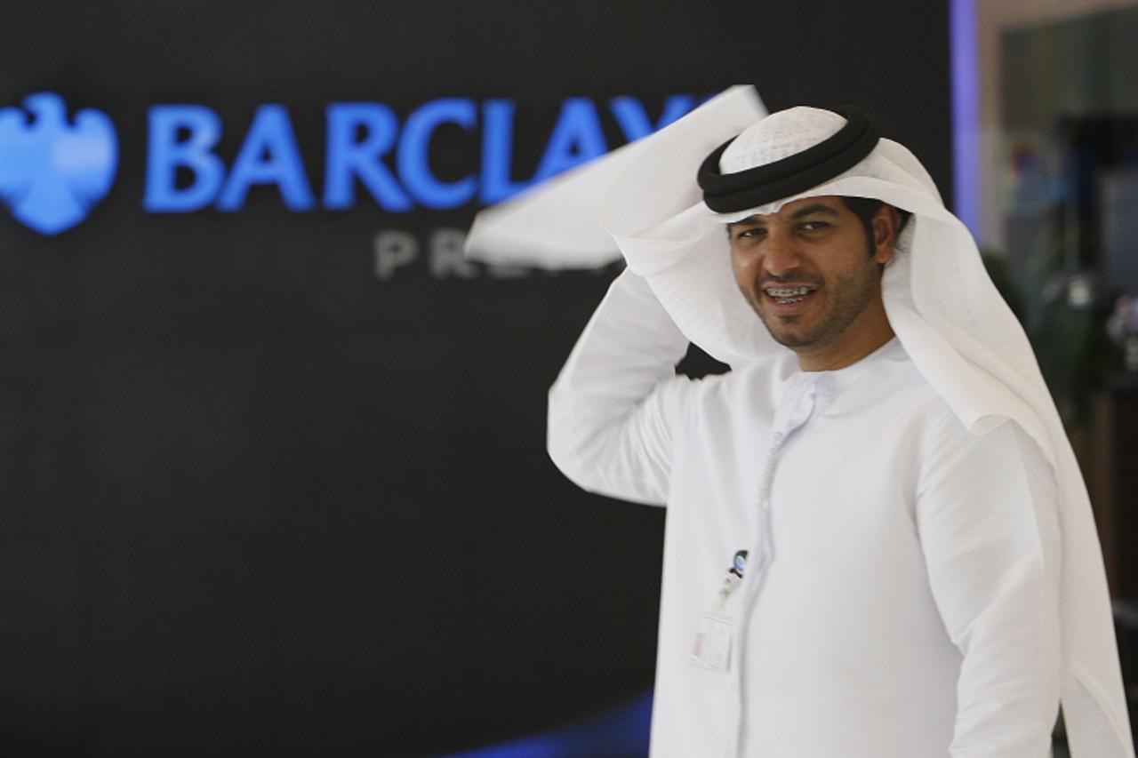 'A man walks past a Barclays logo in a Barclays Bank branch in Dubai November 5, 2008. Sheikh Mansour Bin Zayed Al Nahyan, a member of Abu Dhabi\'s royal family, is to invest up to 3.5 billion pounds 