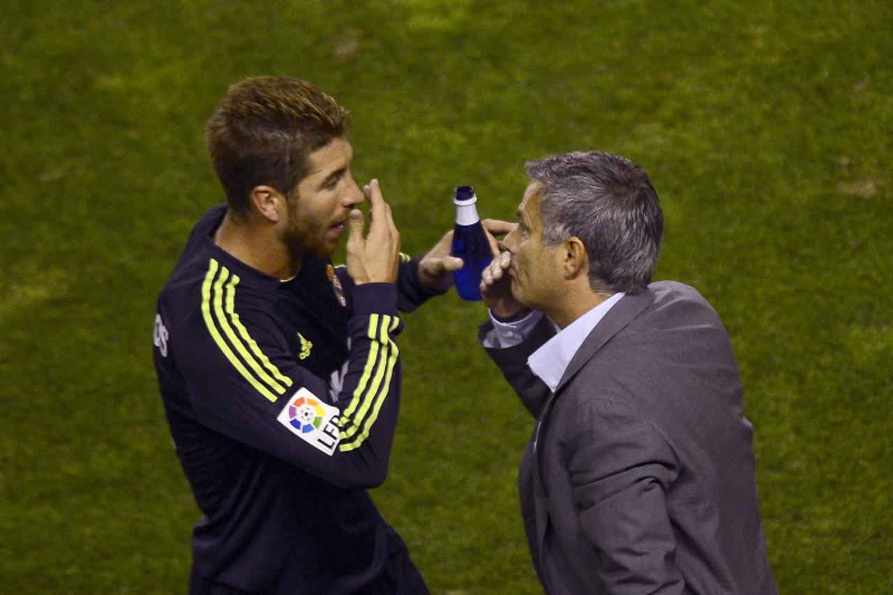 'Real Madrid\'s defender Sergio Ramos (L) speaks with Real Madrid\'s Portuguese coach Jose Mourinho during the Spanish league football match Rayo Vallecano vs Real Madrid on September 24, 2012 at the 