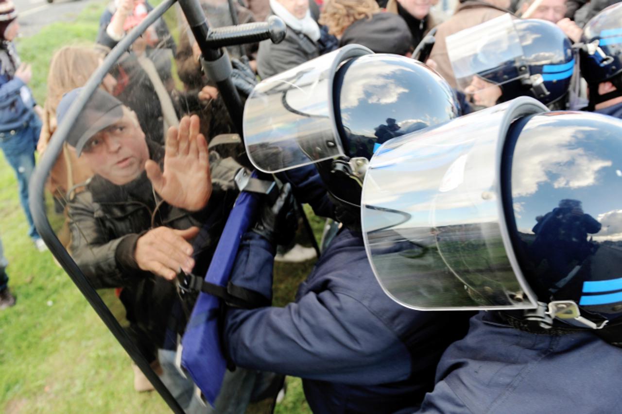 \'Anti riot policemen push demonstrators who block the fuel storage depot of Douchy-Les-Mines, northern France, to protest against French government pensions reform on October 19, 2010.        TOPSHOT