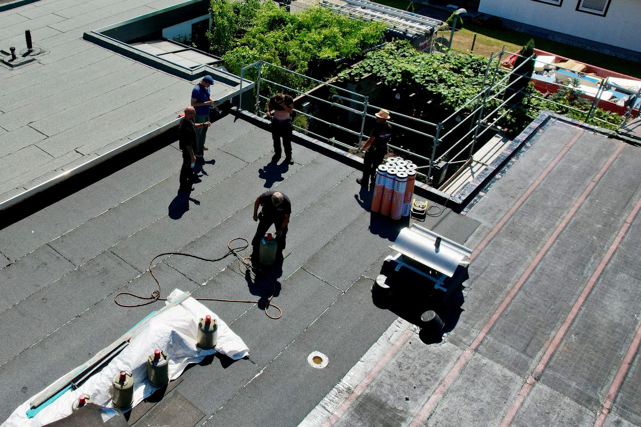 Roofers work during the present heatwave at their construction site in Koenigswinter