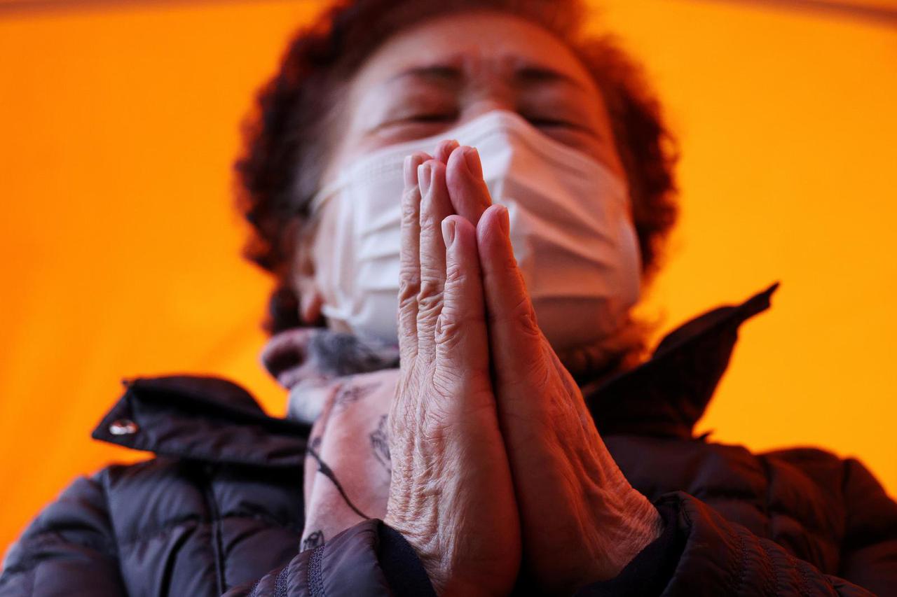 A grandmother prays for her child's success in the annual college entrance examinations, at a Buddhist temple in Seoul