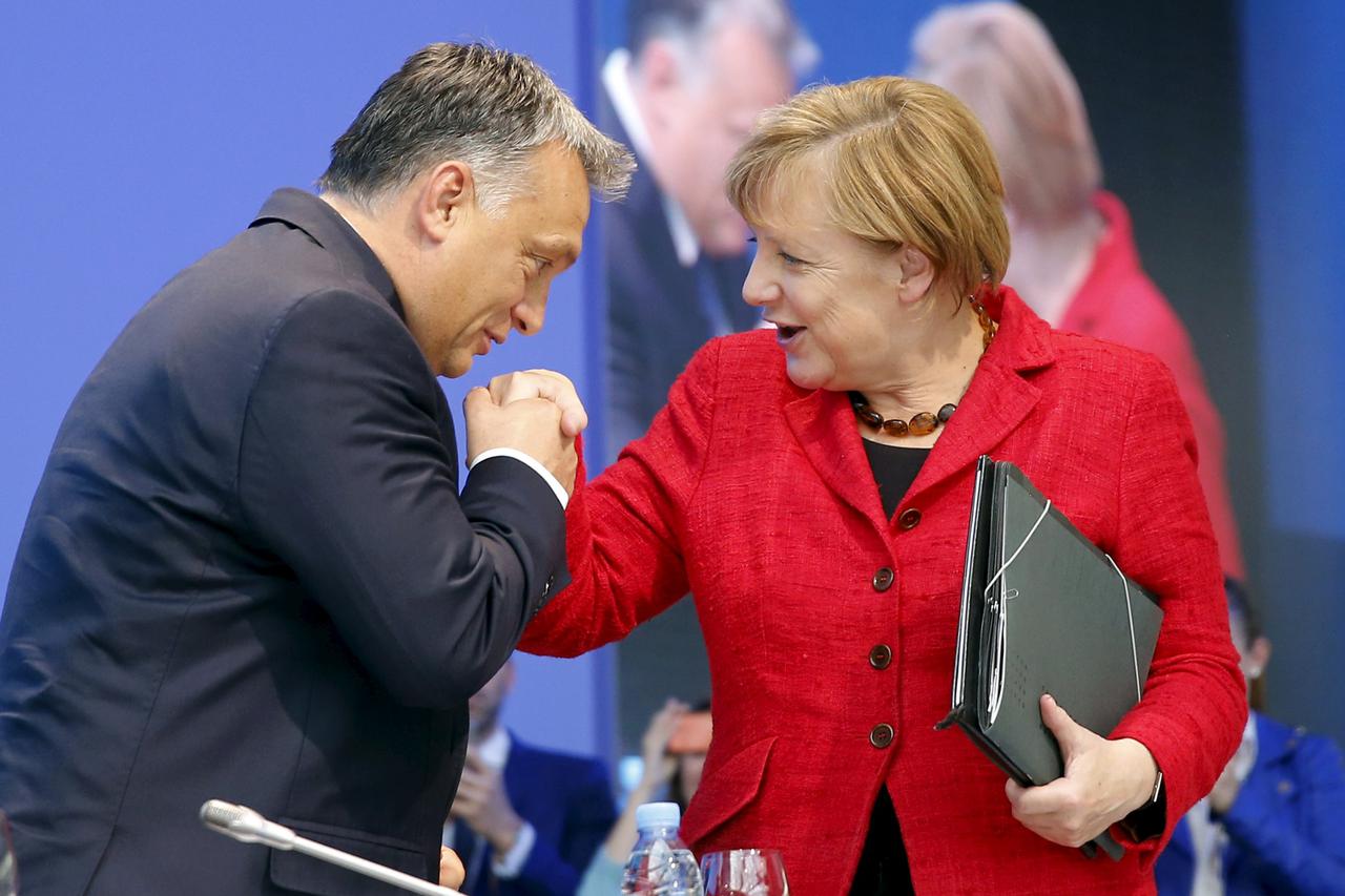 Hungary's Prime Minister Viktor Orban (L) kisses the hand of German Chancellor Angela Merkel as they attend a European People's Party (EPP) congress in Madrid, Spain, October 22, 2015.  REUTERS/Andrea Comas      TPX IMAGES OF THE DAY