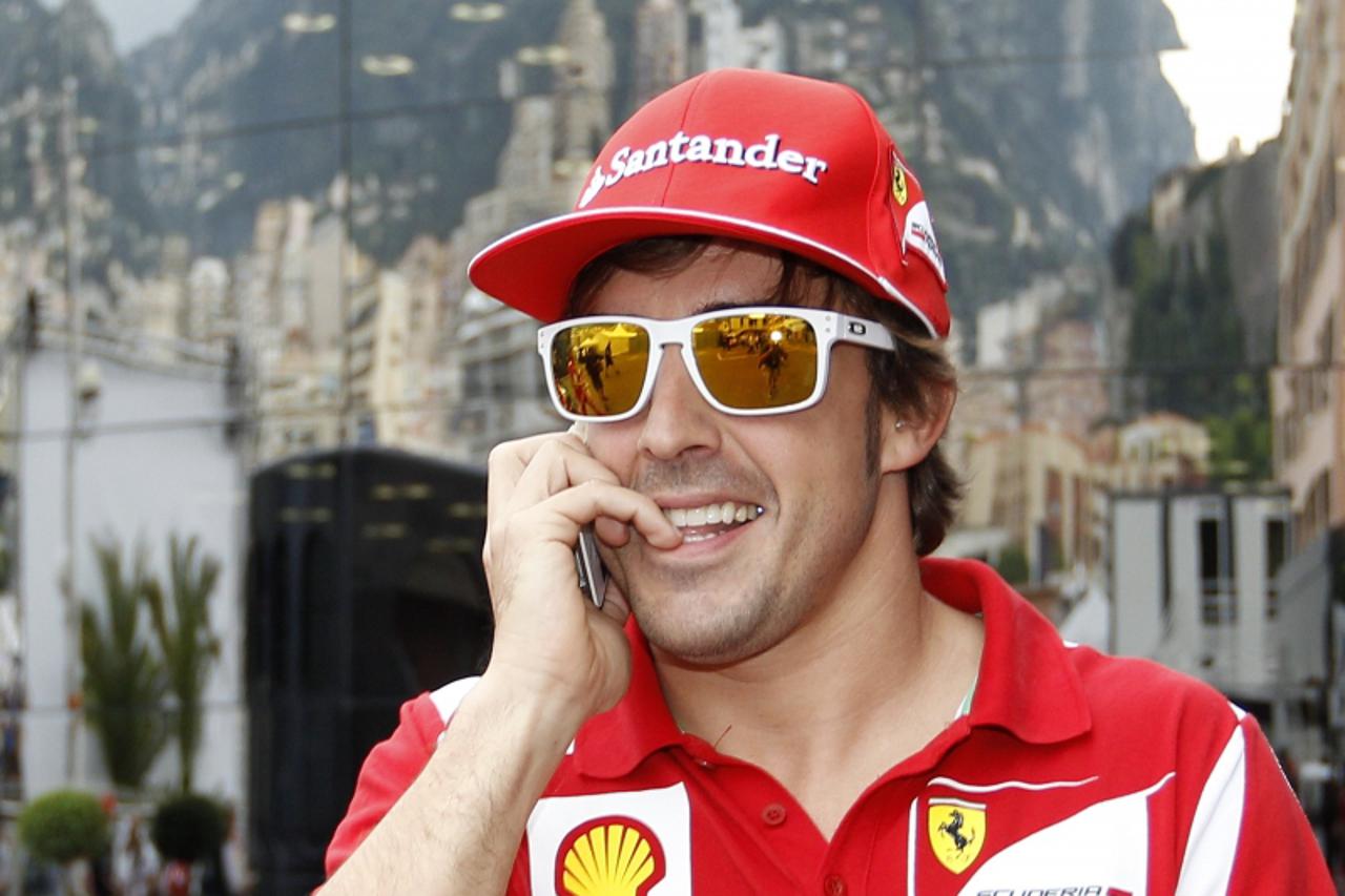 'Ferrari Formula One driver Fernando Alonso of Spain speaks on the phone during the Monaco F1 Grand Prix May 25, 2012.  REUTERS/Max Rossi  (MONACO - Tags: SPORT MOTORSPORT)'