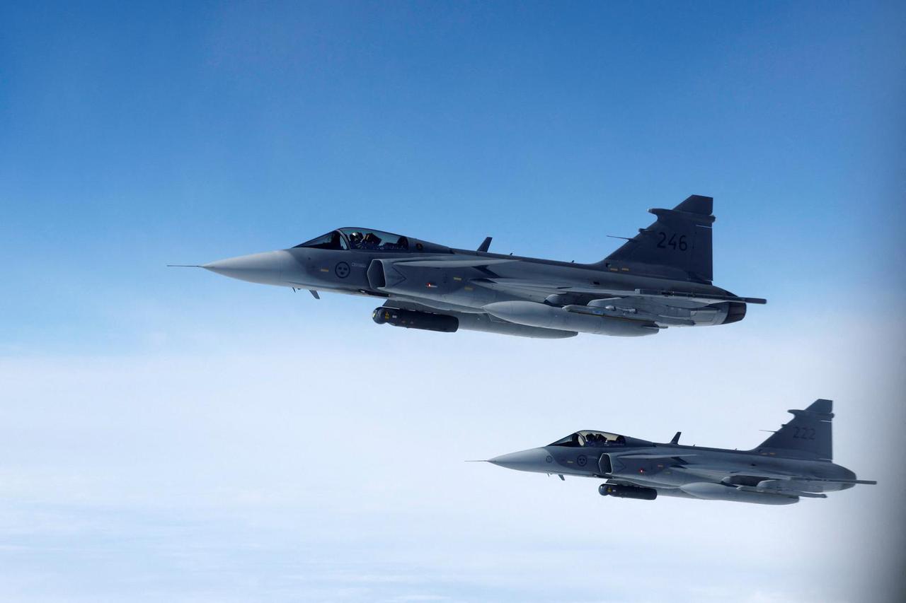 Swedish Air Force Saab JAS 39 Gripen fighter jets fly alongside an aircraft simulating aerial interceptions during a media day