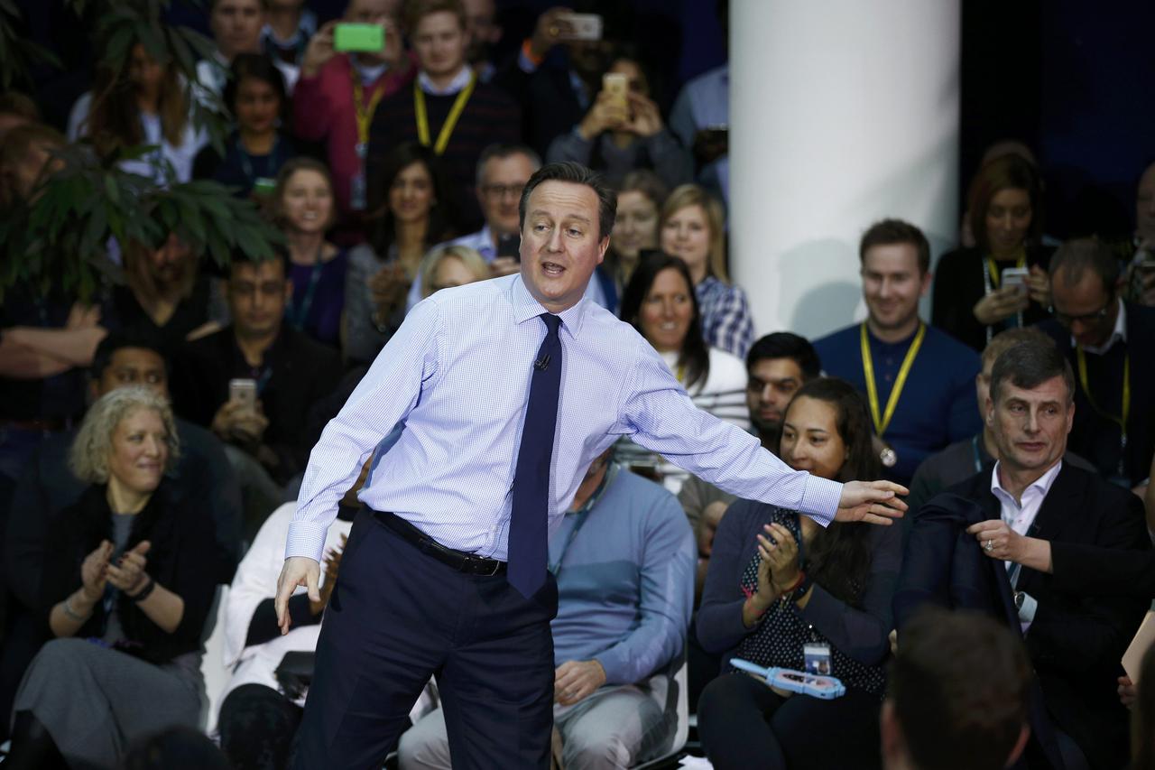 Britain's Prime Minister David Cameron hands his jacket to Karen Brady as he delivers a speech on the European Union to workers and guests at the headquarters of O2 in Slough, west of London, Britain, February 23, 2016. REUTERS/Peter Nicholls