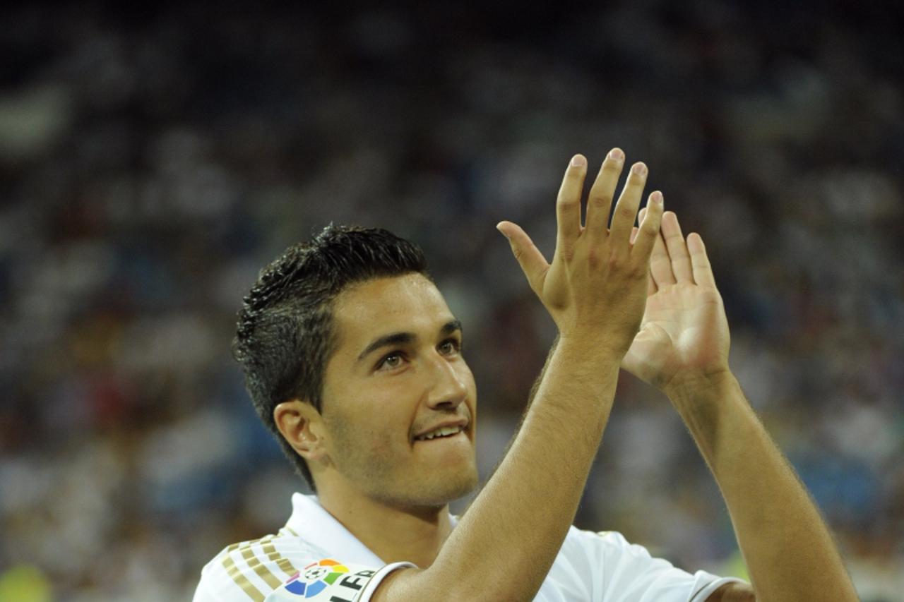 \'Real Madrid\'s Nuri Sahin claps while standing in the line up before his team\'s Santiago Bernabeu trophy match against Galatasaray at the Santiago Bernabeu Stadium, on August 24, 2011 in Madrid. AF