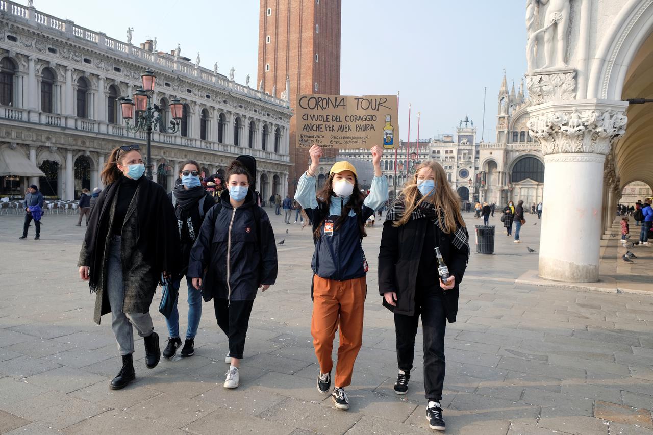 People wear protective face masks as they walk in St. Mark's square after the last days of Venice Carnival were cancelled due to coronavirus, in Venice