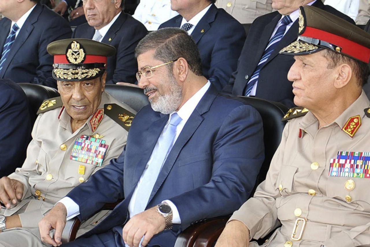 'Egypt's new Islamist President Mohamed Mursi (C) speaks with Field Marshal Hussein Tantawi (L) and Egyptian Armed Forces Chief Of Staff Sami Anan during a soldier graduation ceremony at the Egyptian