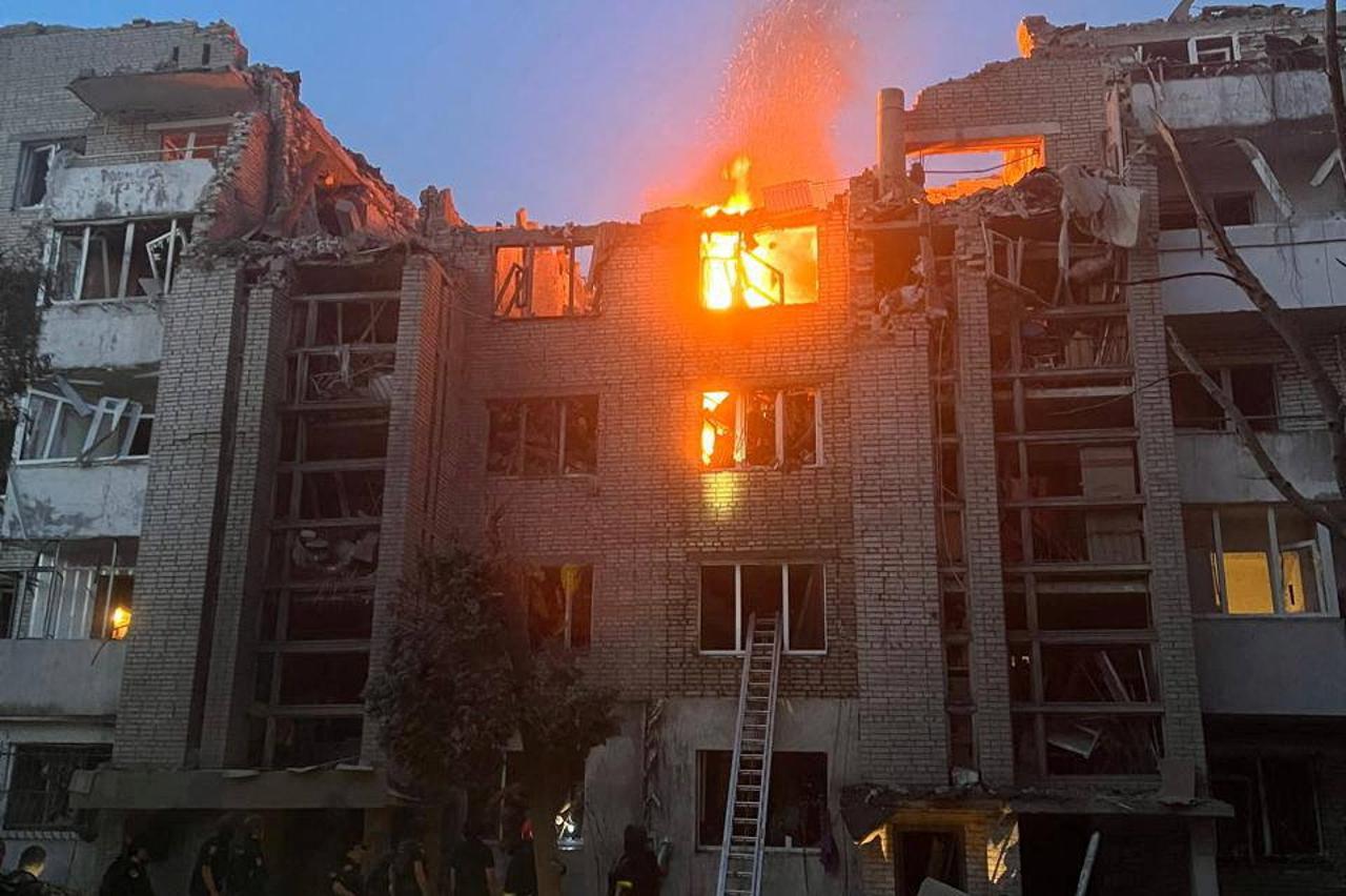 Firefighters work at a site of a building damaged by a Russian missile strike in Lviv