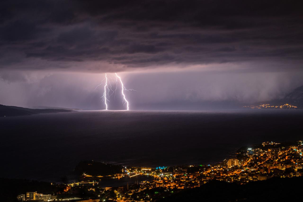 Pogled na Makarsku i munje u bračkom kanalu prema Splitu